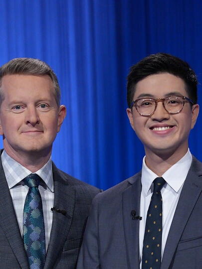 Jeopardy host stands beside winner on set