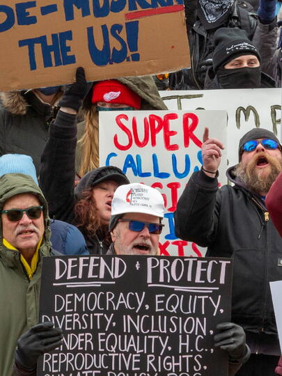 Photo of people protesting and holding up signs. One sign says: "Accountability."