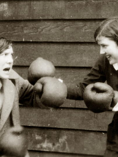 Two students pretend to box with boxing gloves