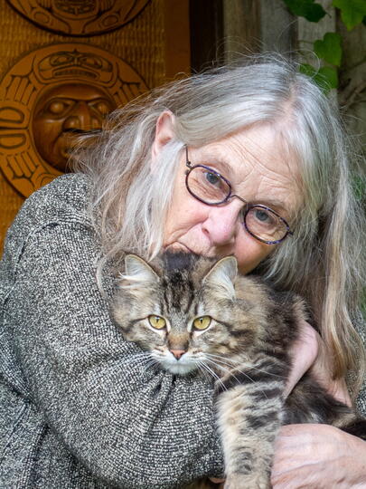A photo of Susan Musgrave clutching a cat to her chest