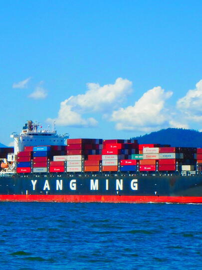 Freighter on water in front of mountains