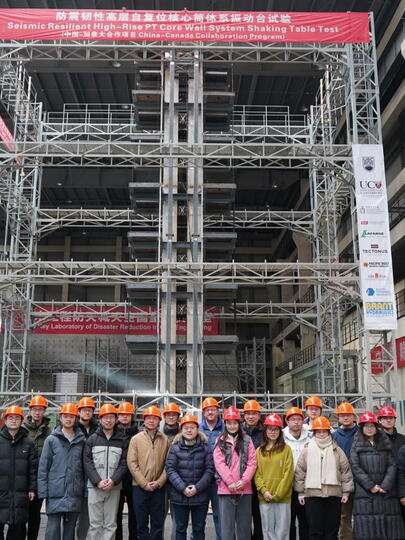 Group of people wearing hardhats in front of scaffolding structure