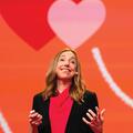 Photo of Dr. Elizabeth Dunn on a stage with a red background